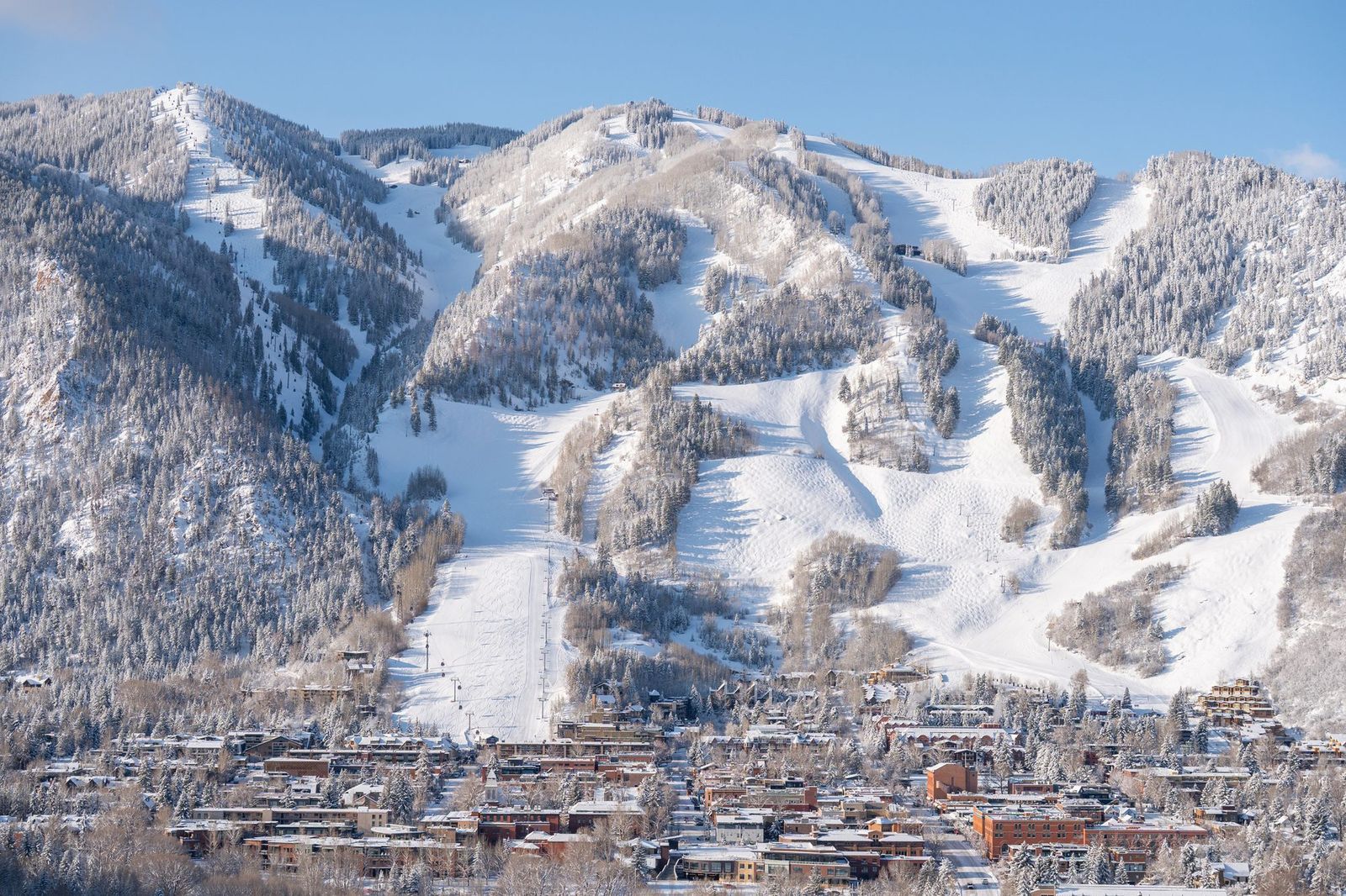 El pueblo de Aspen al pie de la montana de esqui, con las pistas encima de las casas