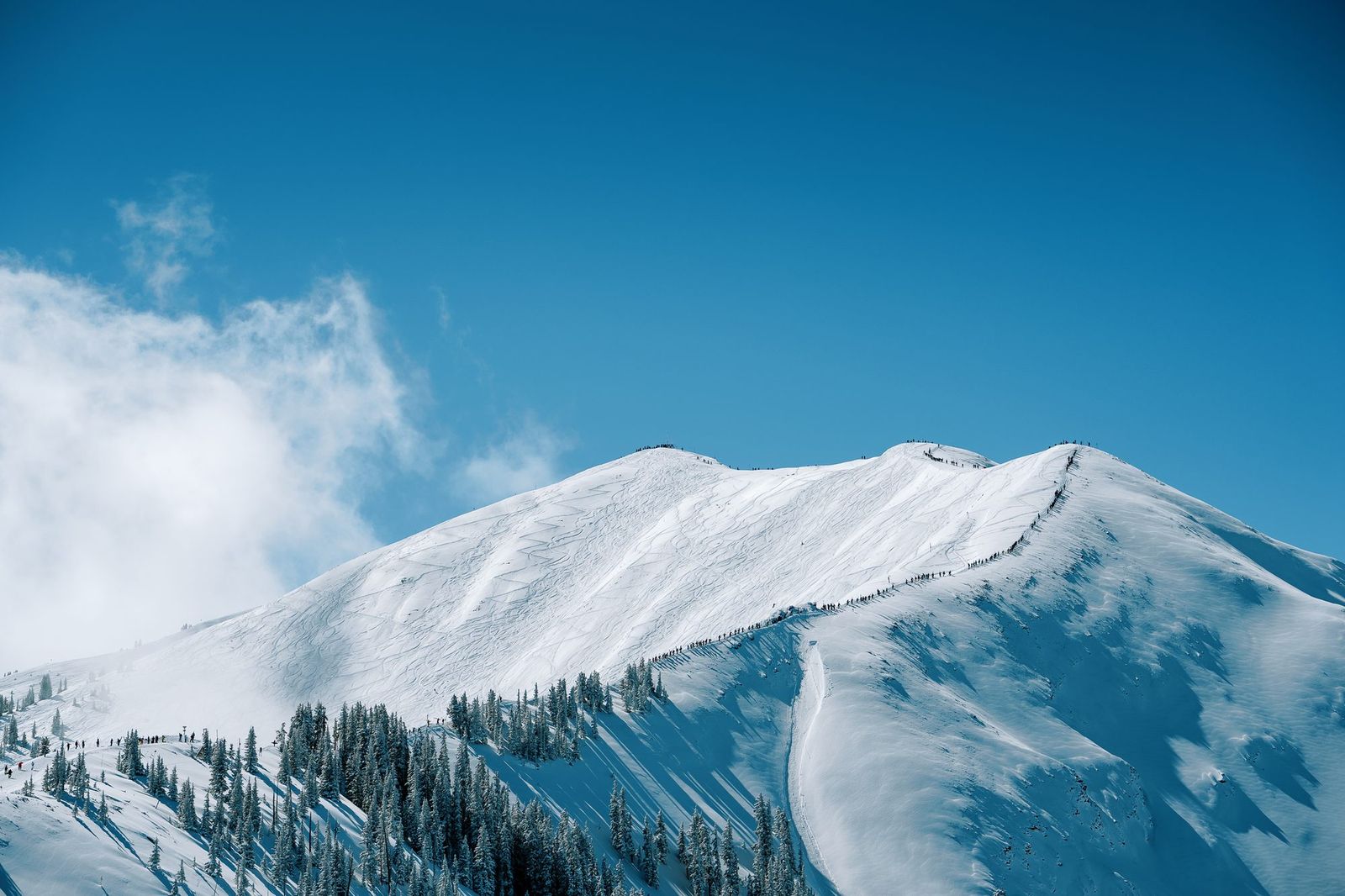 Cresta nevada del Highland Bowl de Aspen sobre un mar de nubes