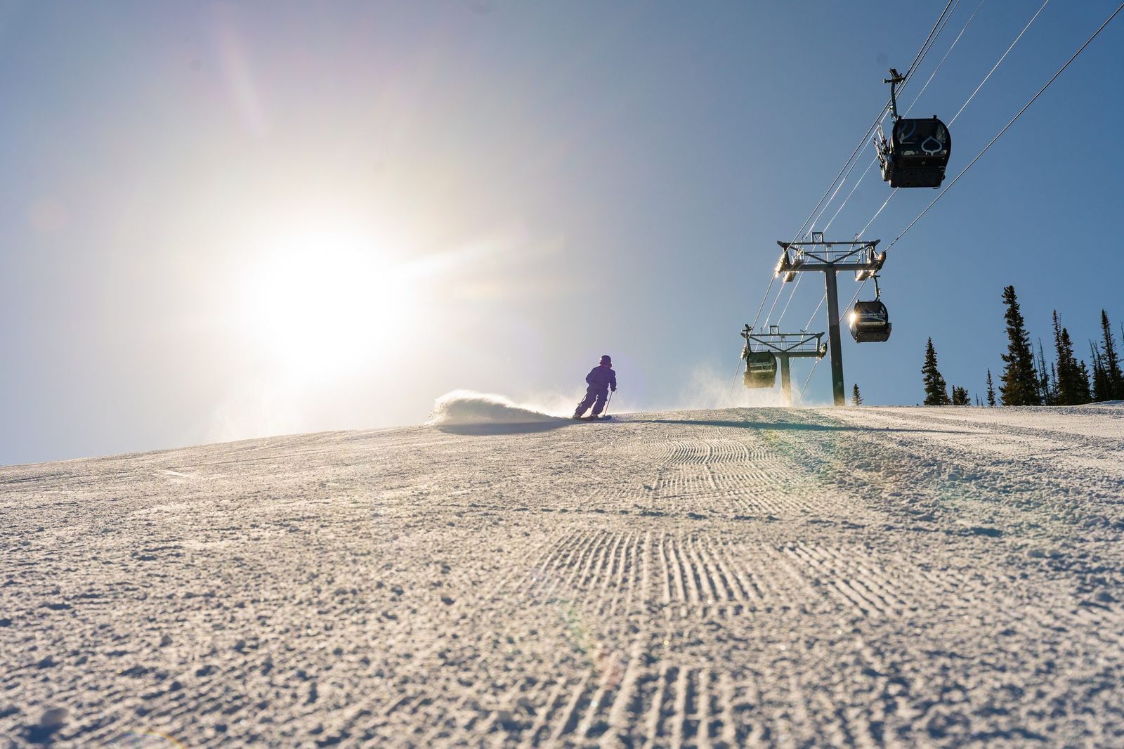 Pista reci&eacute;n pisada al amanecer en Aspen con la telecabina al fondo